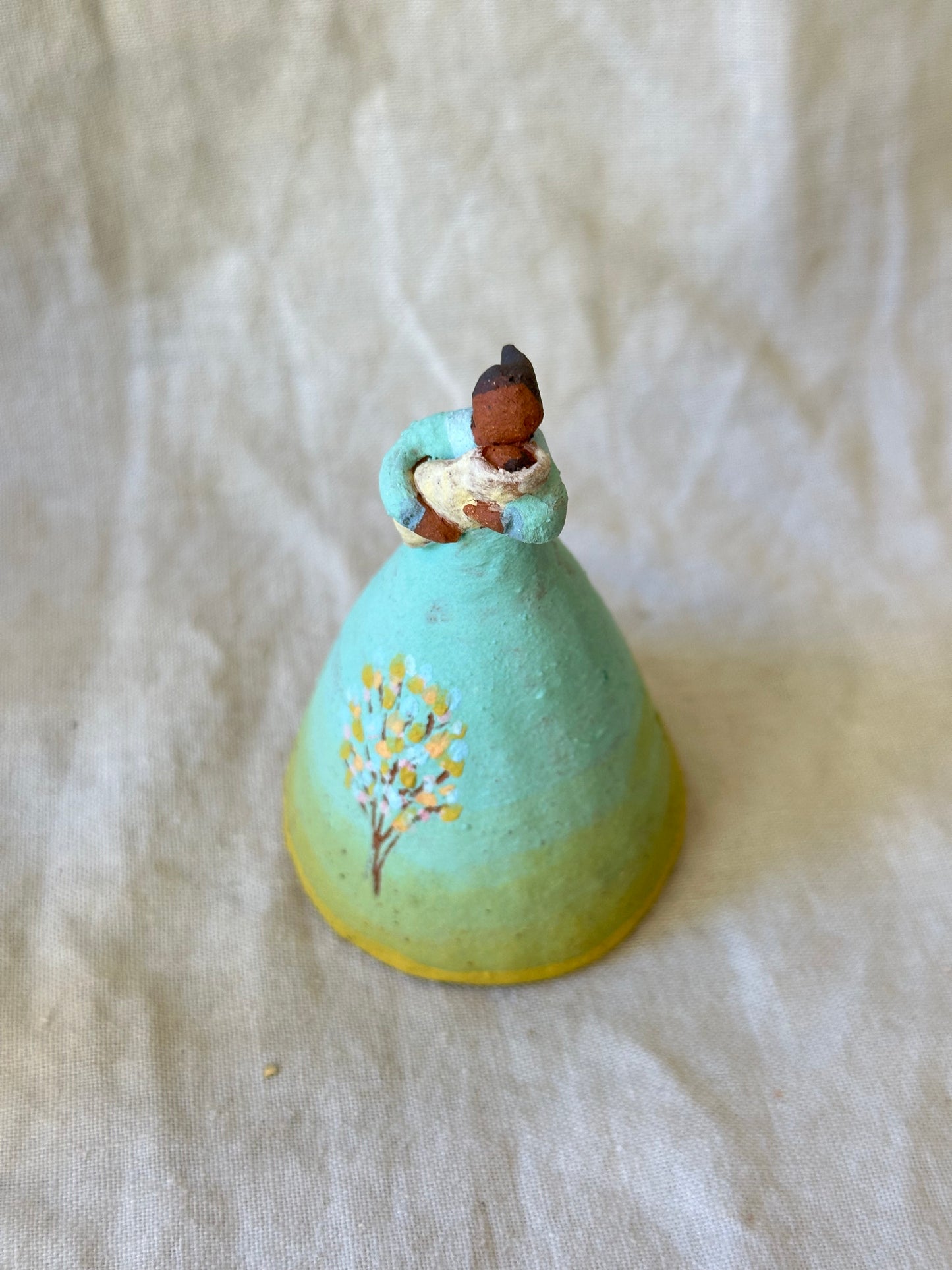 Dancer Bell holding a baby - aqua and yellow trim dress