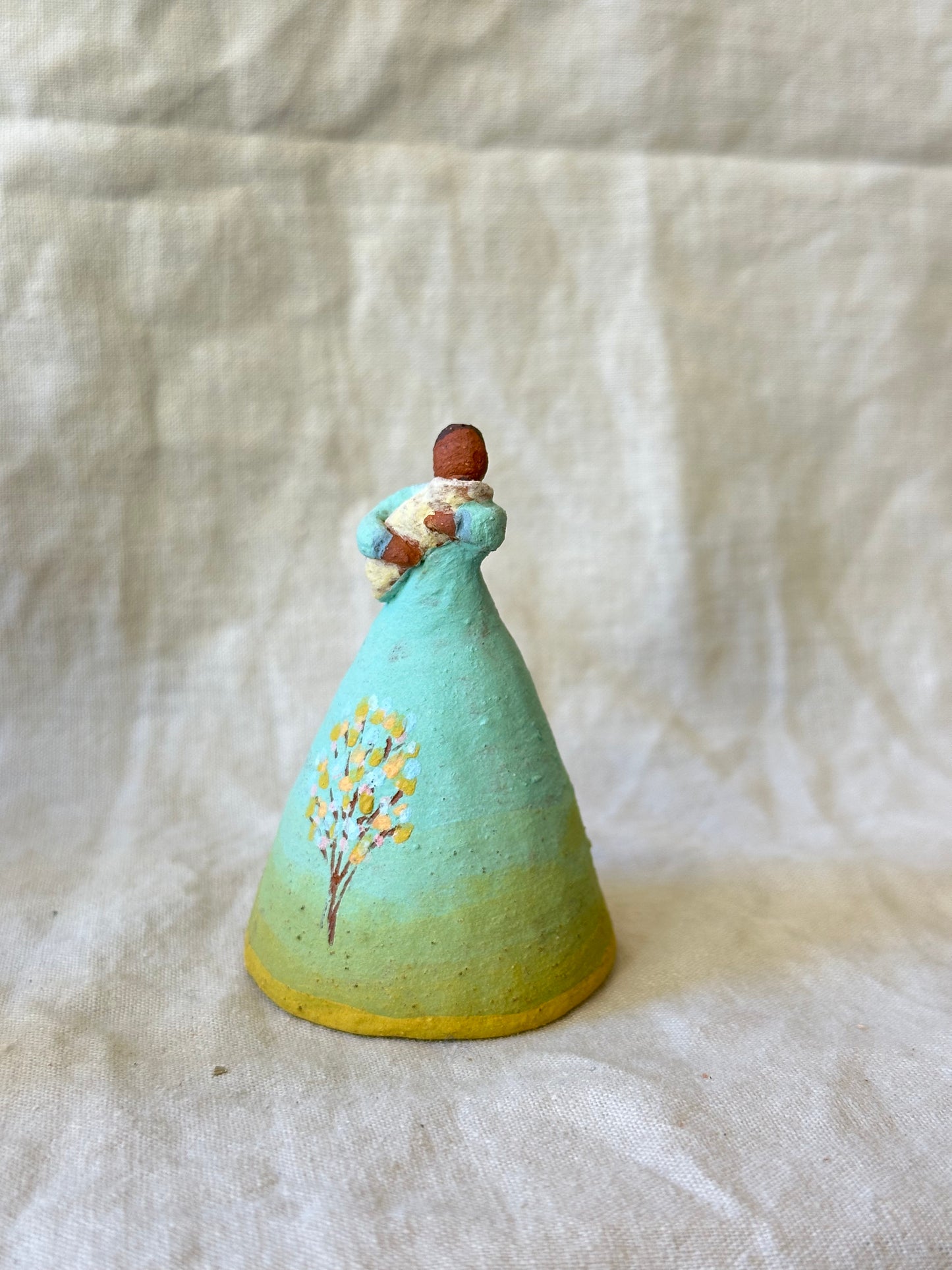 Dancer Bell holding a baby - aqua and yellow trim dress
