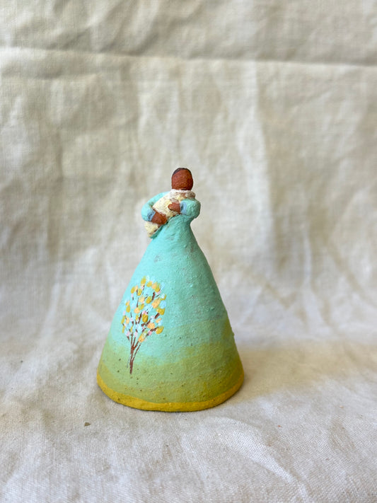 Dancer Bell holding a baby - aqua and yellow trim dress