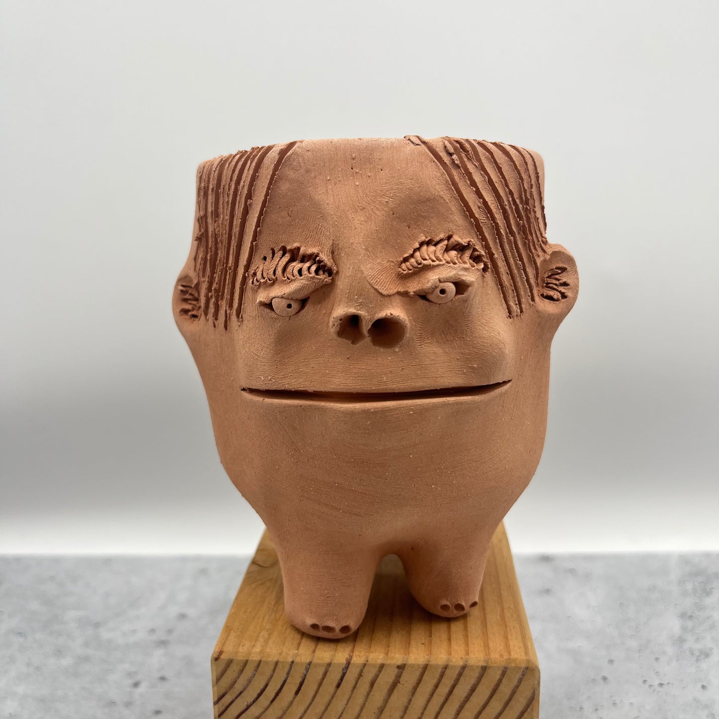 Terracota face planter with legs