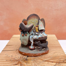 Load image into Gallery viewer, Bench with boat miniature sculpture - yellow rain coat
